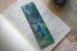 A vibrant artistic bookmark placed in an open notebook showcasing elegant handwriting.